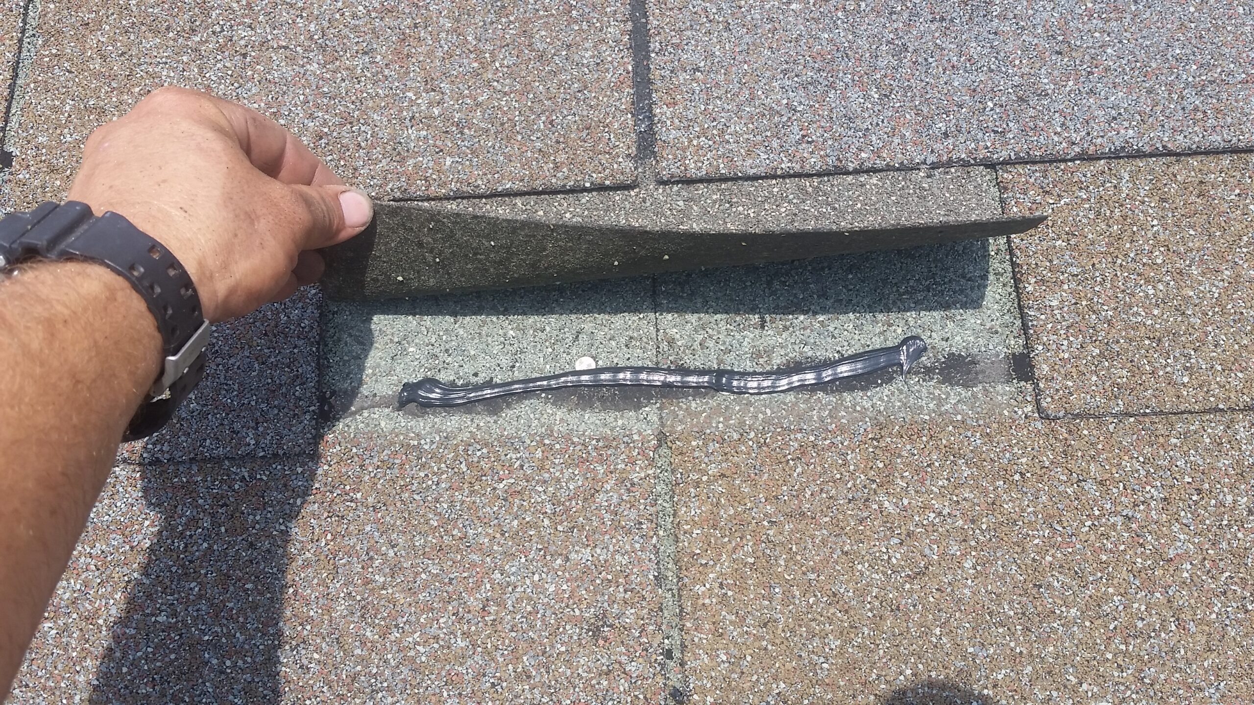 Caulking by hand is done to resecure the upper shingle