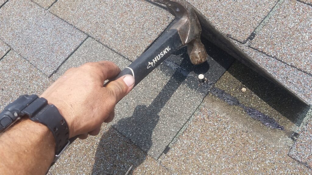 Fasten the tab down with galvanized roofing nails, staying in the nail line. This nail is a little high, but still catches the shingle underneath.